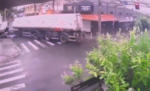 Carreta que entrava em posto derruba poste de semáforo e fiação prende outro caminhão no Centro